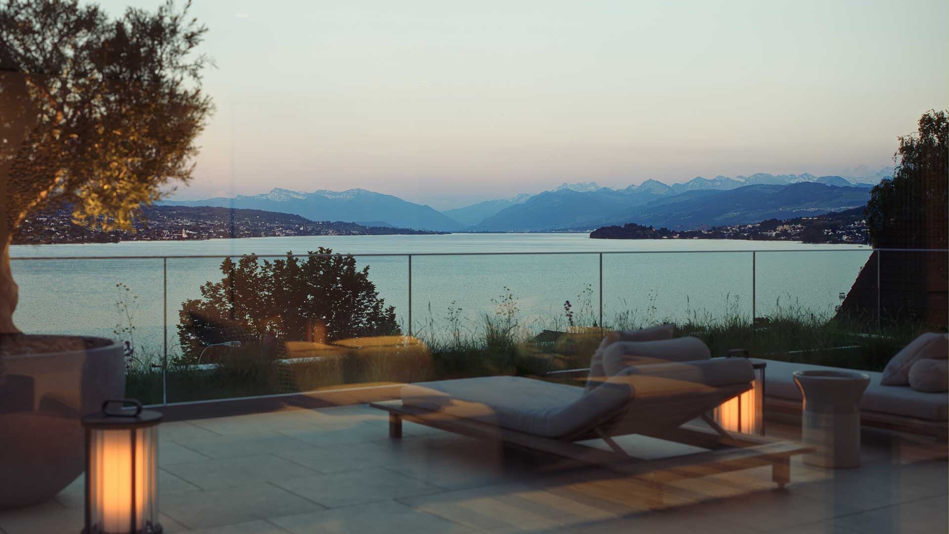 Terrasse der Liegenschaft ICONIC in Oberrieden mit Blick auf den Zürichsee und die Schweizer Alpen bei Dämmerung